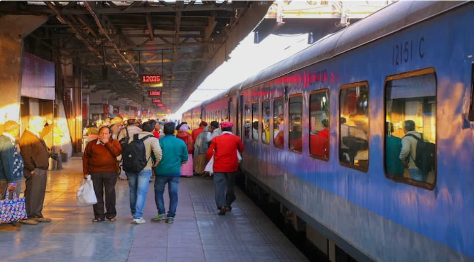 रेलवे टिकट जुर्माना 500 रुपये नियम से जुड़ी सांकेतिक तस्वीर, भारतीय रेलवे स्टेशन पर खड़ी ट्रेन और टिकट के साथ बढ़े हुए जुर्माने का संकेत।